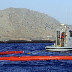 Souda Bay, Kreta, Grekland (23 juli 2008) Ett team för oljeutsläppsrespons vid U.S. Naval Support Activity Souda Bay implementerar ett "Harbour Buster" snabbsystem för inneslutning av olja under en övning för att testa procedurer för att innesluta och återvinna olja vid ett utsläpp. Källa: Wikipedia Common, Bild från den amerikanska flottan av Mr. Paul Farley